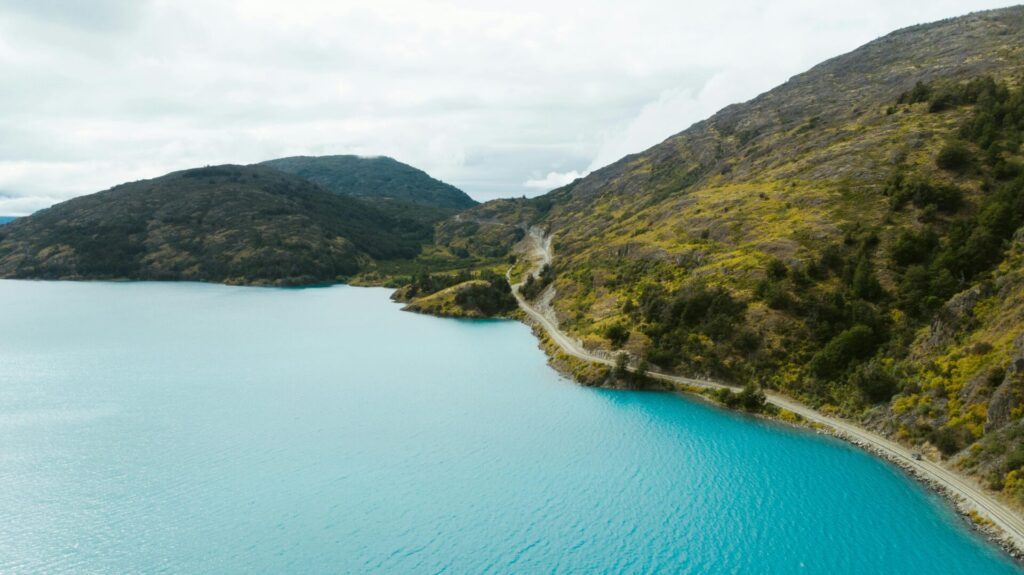 Carretera costera al pie de una montaña que crean un paisaje natural de pelicula en chile
