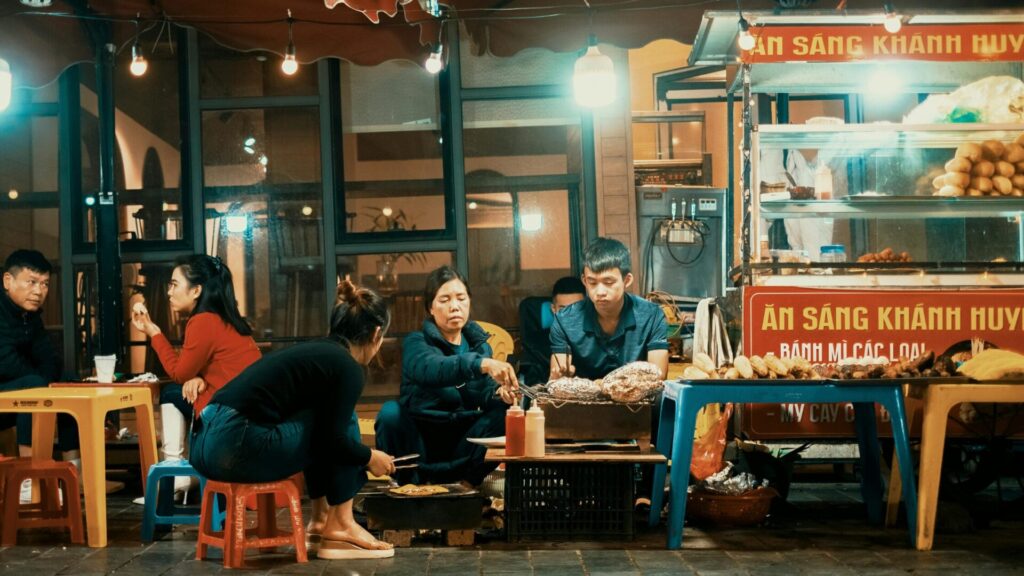calle noctura en vietnam, restaurante local con sillones y mesas bajas de plastico