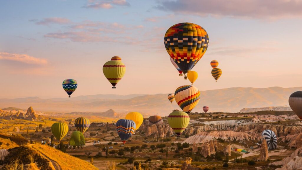 Amanecer en Capadoccia, Turquía con globos aeros y las montañas de fondo