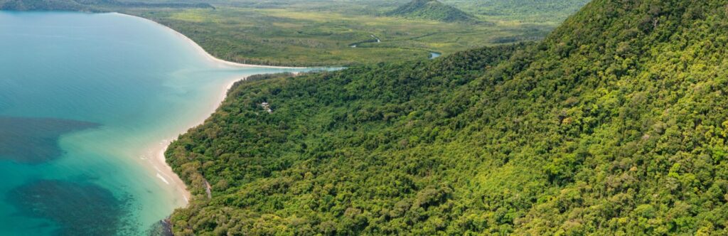 Paisaje de montañas verdes con el mar pegado a la izquierda