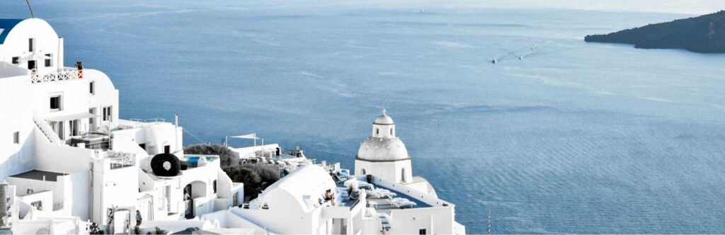Views of blue and white Greek buildings with the sea in the background