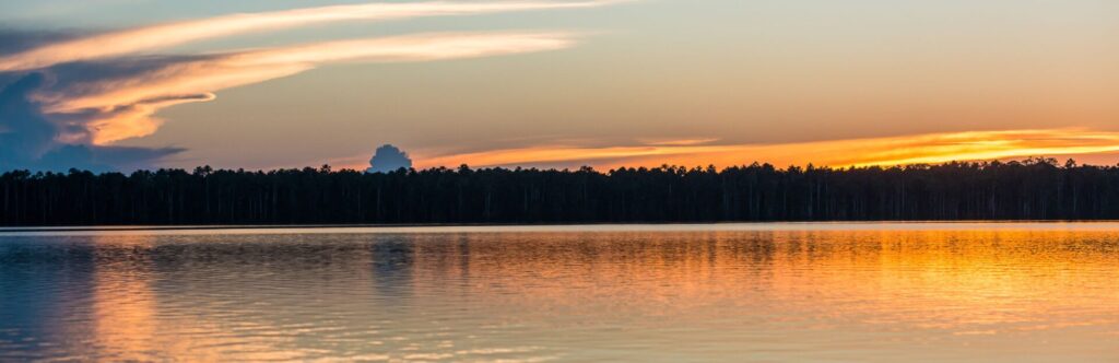 Paisaje de un lago con atardecer de fondo