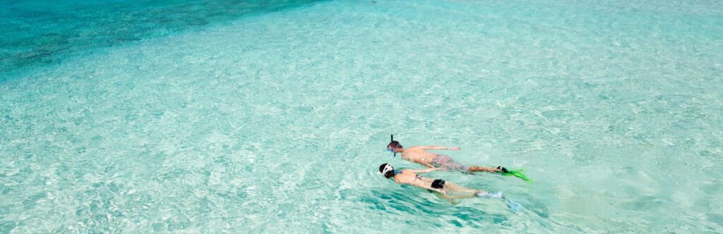 Image of two people snorkeling in crystal clear waters