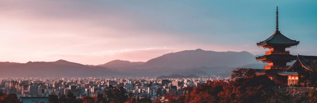 High views of the city of Japan with mountains in the background and a temple on the right